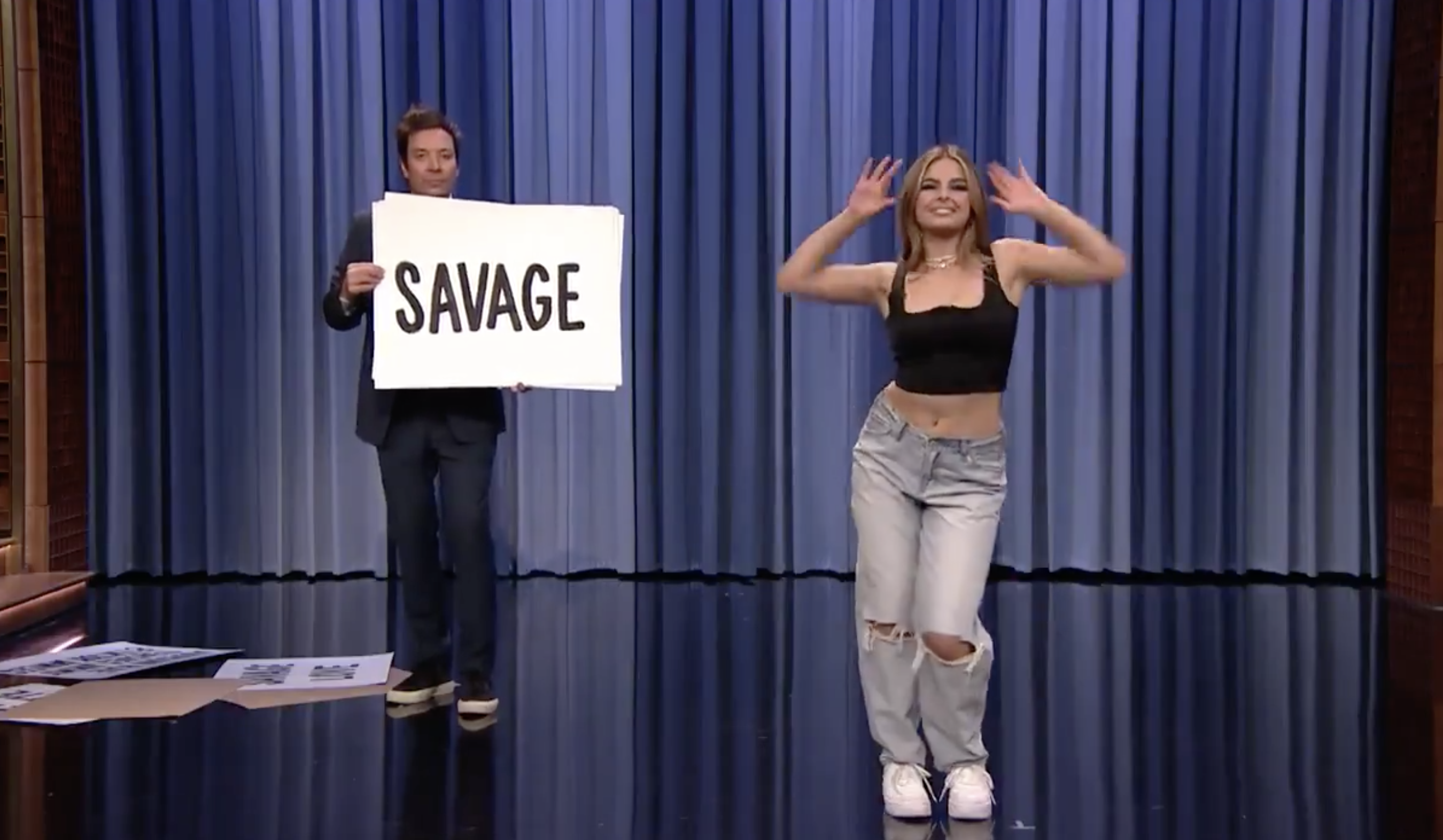 Scene from the Fallon show with Jimmy holding up a sign that says &quot;Savage&quot; standing onstage with Addison Rae