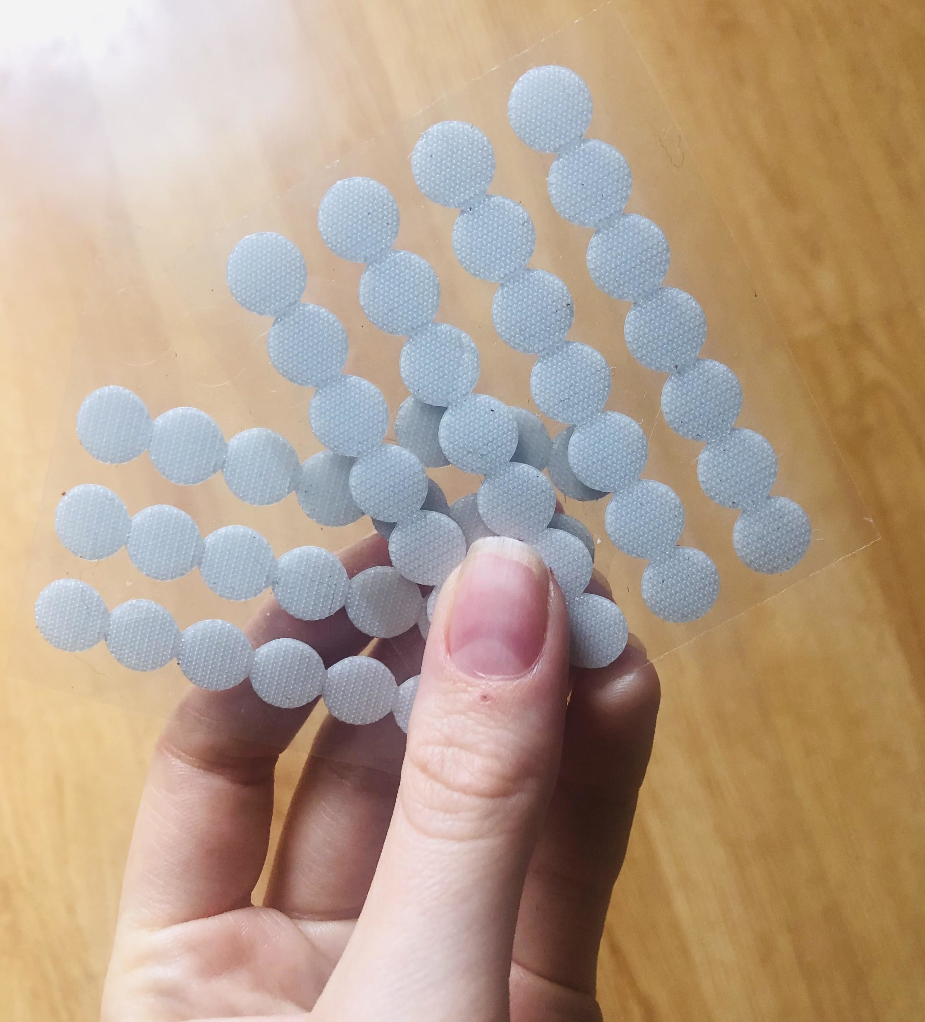 A person holding two sheets of the dots