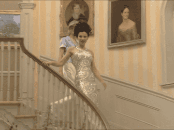 Fran walking down the stairs in sparkly gown