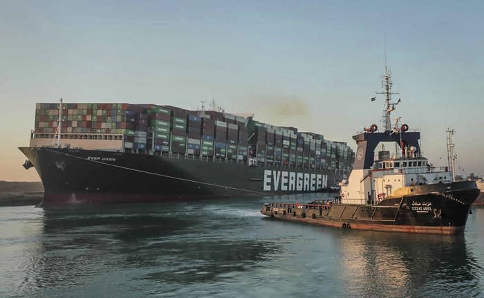 A tug boat pulls the cargo ship