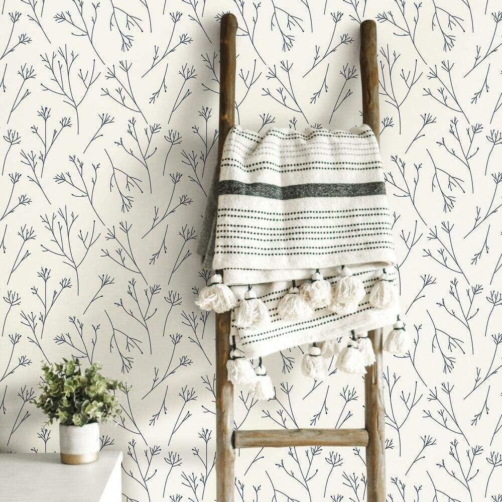 A wall covered in wallpaper with a minimalist pattern of twigs