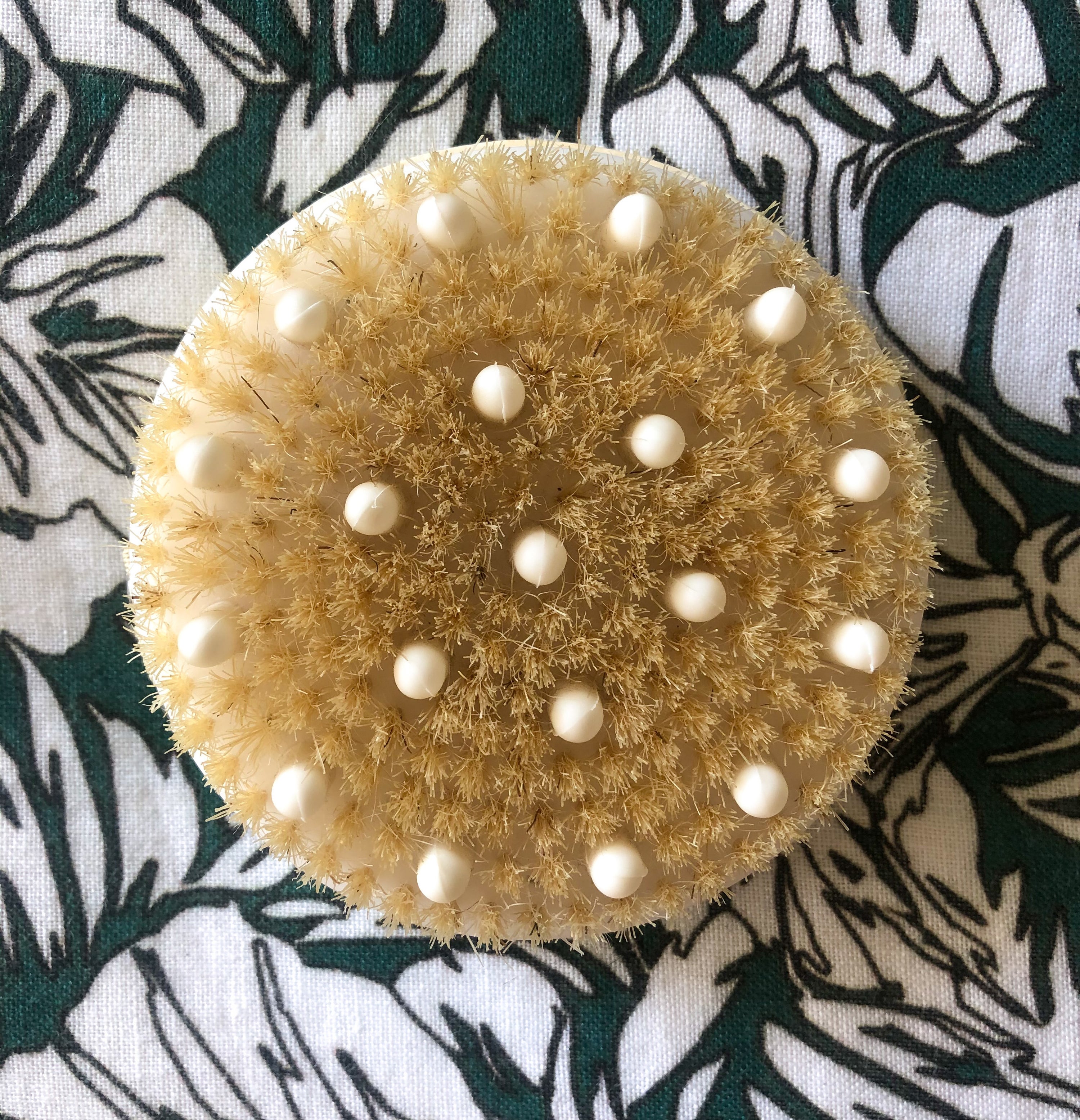 A flatlay of the body rush with rubber nodes on a patterned fabric