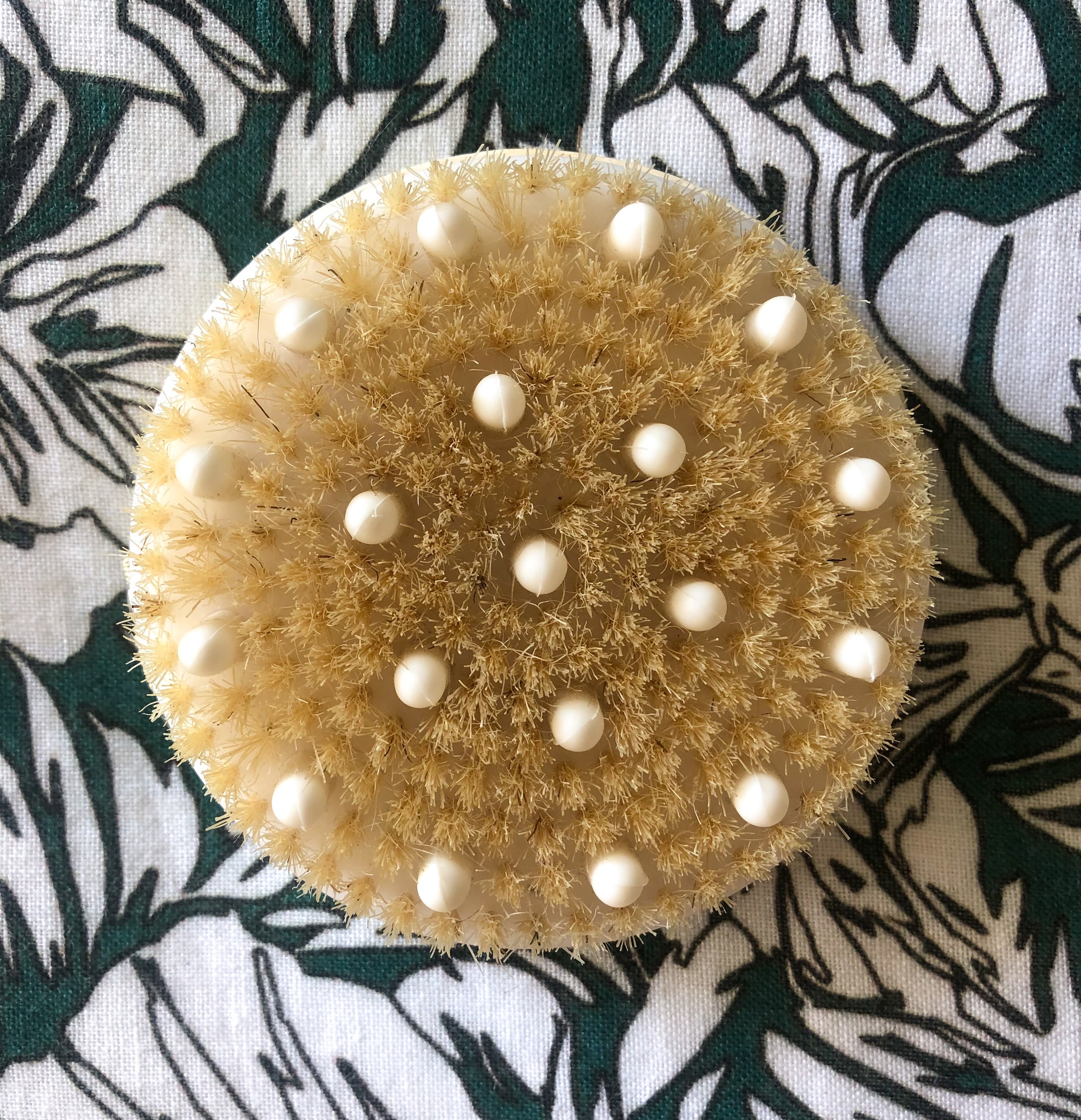 A flatlay of the body rush with rubber nodes on a patterned fabric