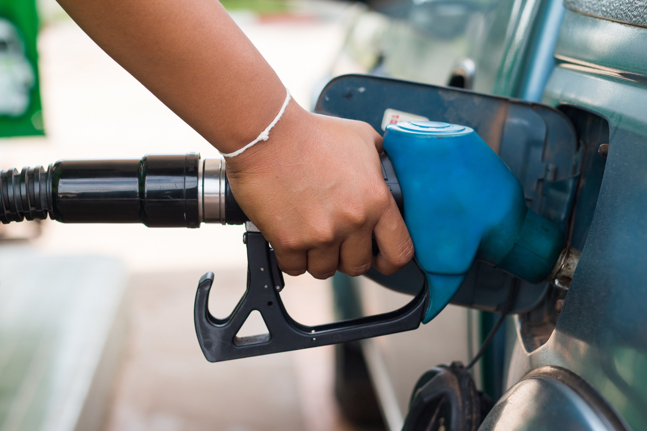 A person fills up their gas tank at a station.