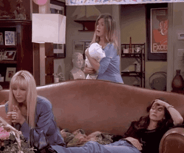 Rachel rocks one baby, Phoebe claps to entertain another, and Monica lays with her hand pinching her nose on the couch