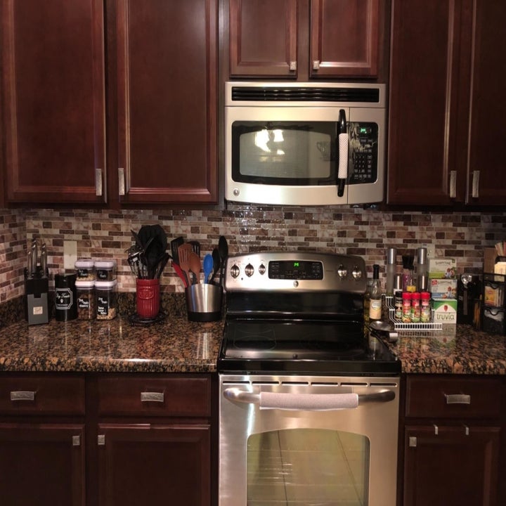 reviewer image of the brown marble peel and stick tile used as backsplash in a kitchen