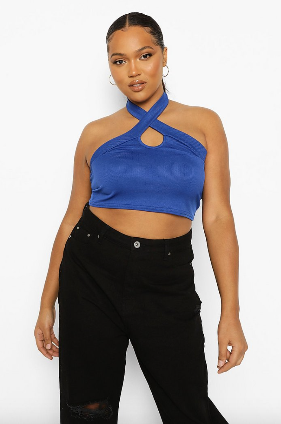 plus size model wearing a crop halter top shirt with a keyhole detail styled with high-waist jeans