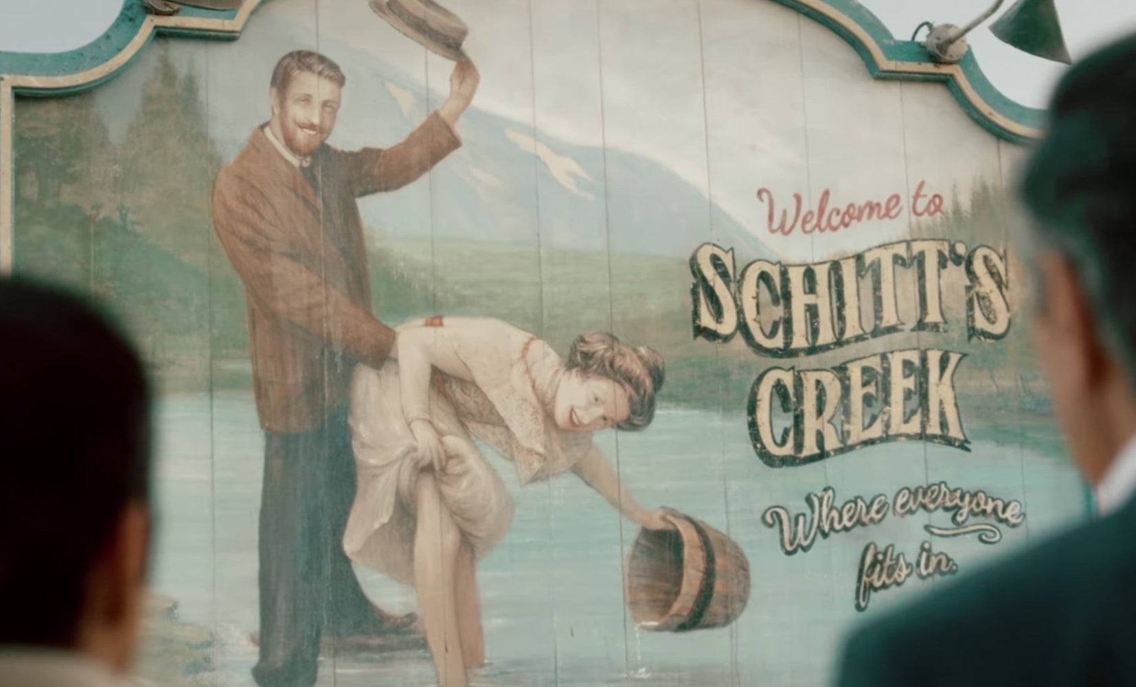 Schitt&#x27;s creek town sign, man and woman suggestively in river