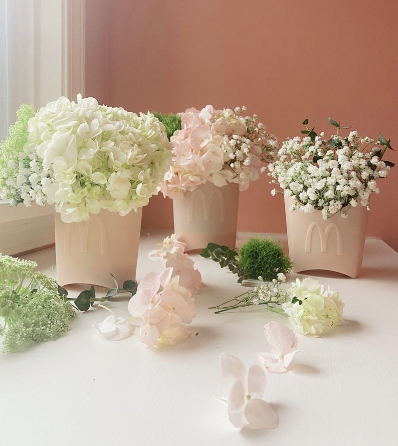 three pale pink vases with flowers in them that look like McDonald&#x27;s french fry containers 