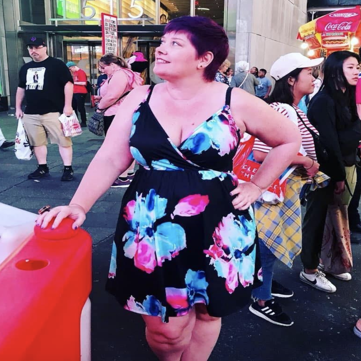 reviewer wearing the black dress with floral design