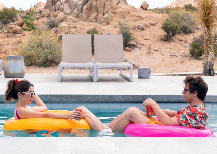 Cristin Milioti and Andy Samberg drinking on floaties in a pool