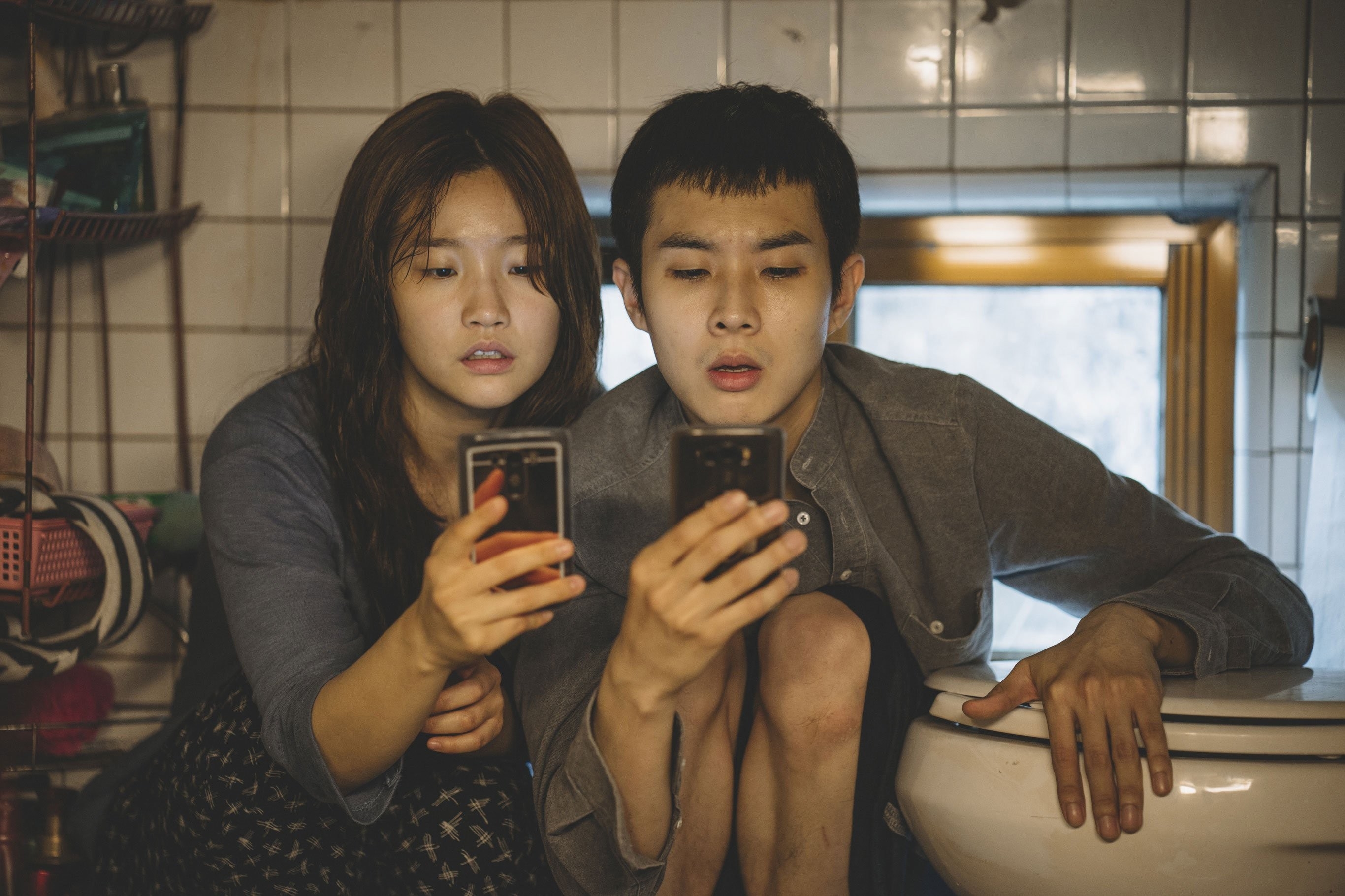Park So-dam and Choi Woo-sik looking at their phone
