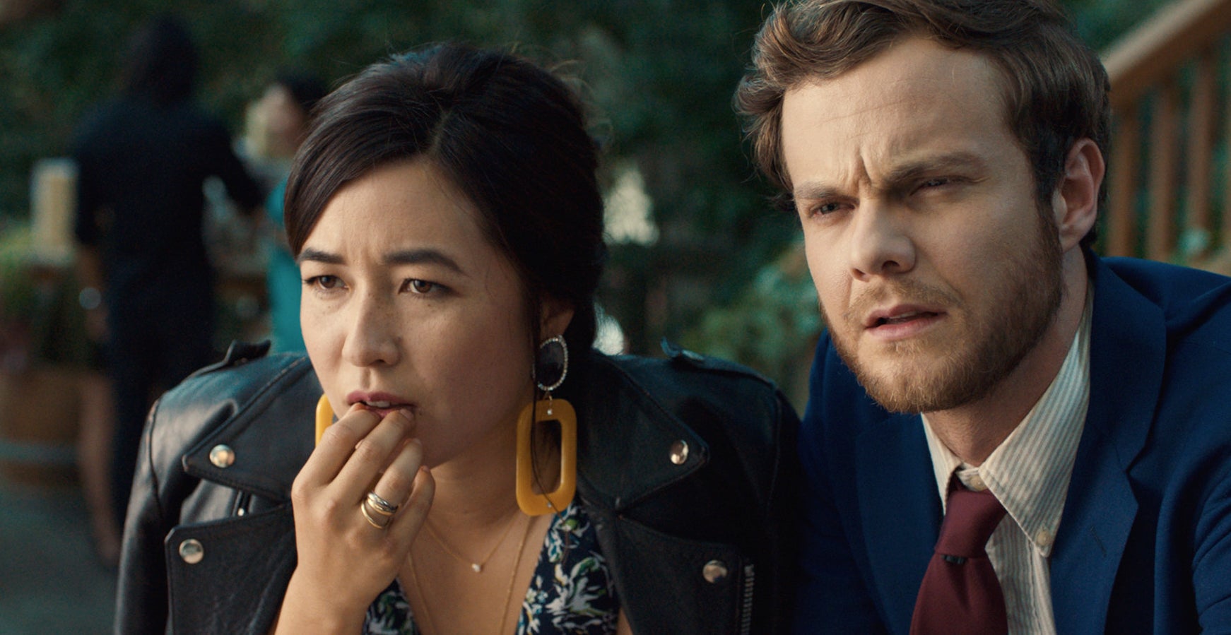 Maya Erskine and Jack Quaid looking serious while sitting down at an event