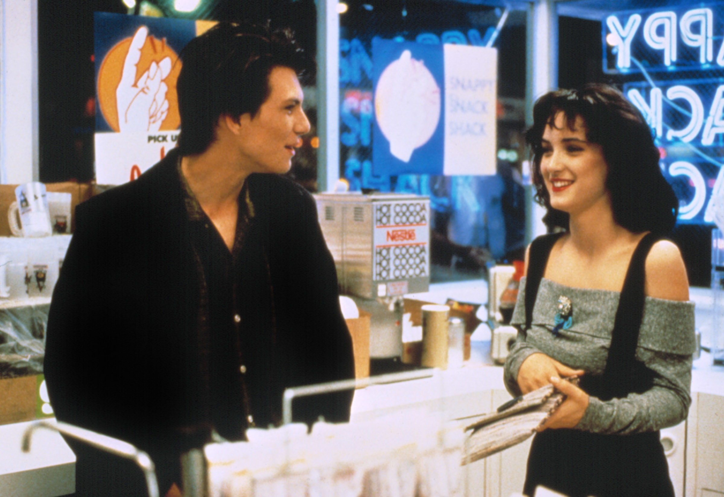 Christian Slater and Winona Ryder laughing inside a store