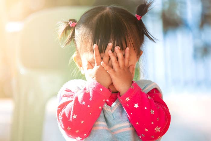Little girl with her hands over her face