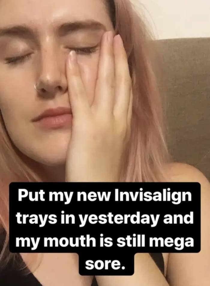 Shelby holding her jaw in pain saying, &quot;Put my new Invisalign trays in yesterday and my mouth is still mega sore&quot;