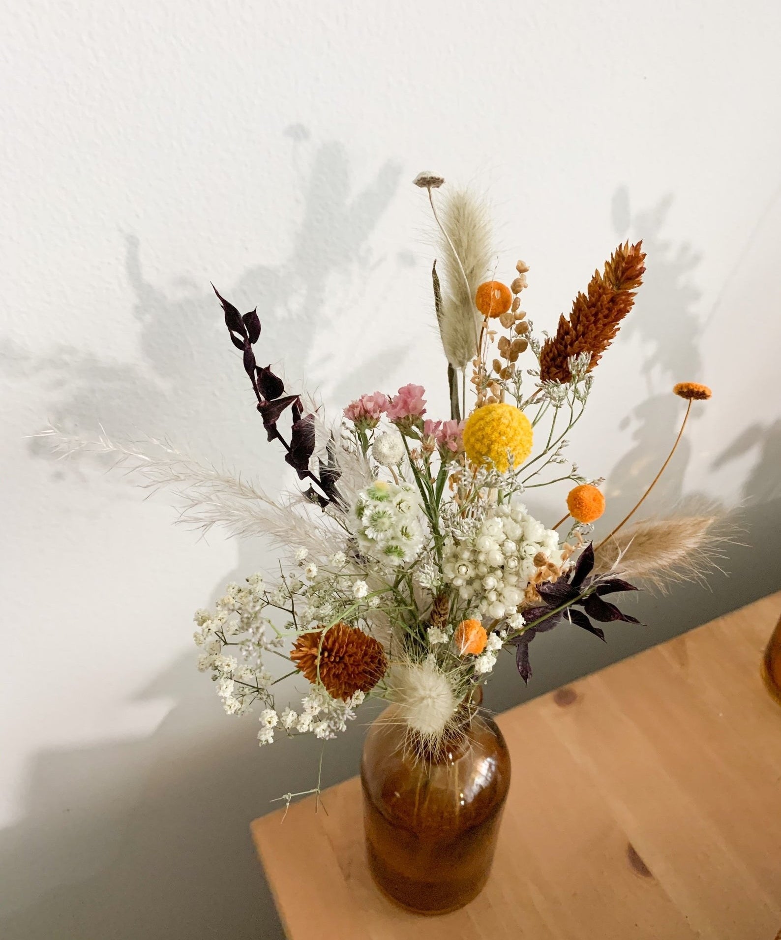 the rustic dried arrangement in an amber vase