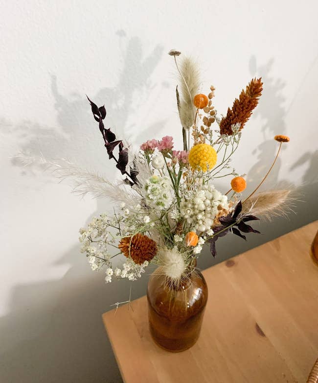 the rustic dried arrangement in an amber vase