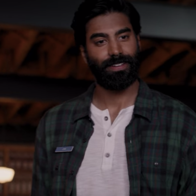 A cafe owner is standing at a table, greeting guests