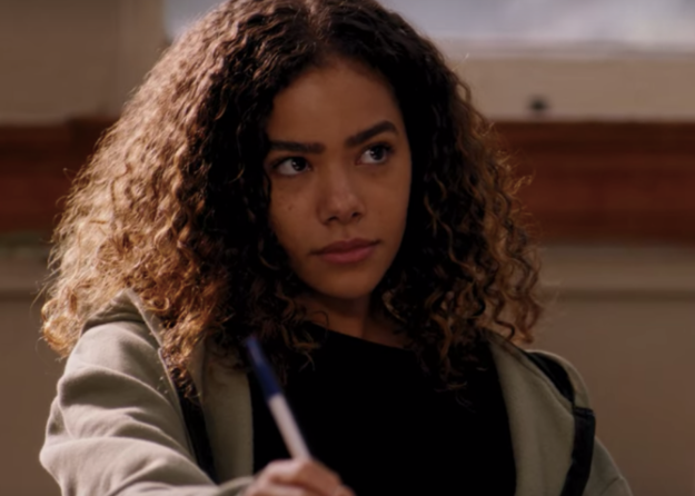 A student is sitting at a desk while writing on a paper