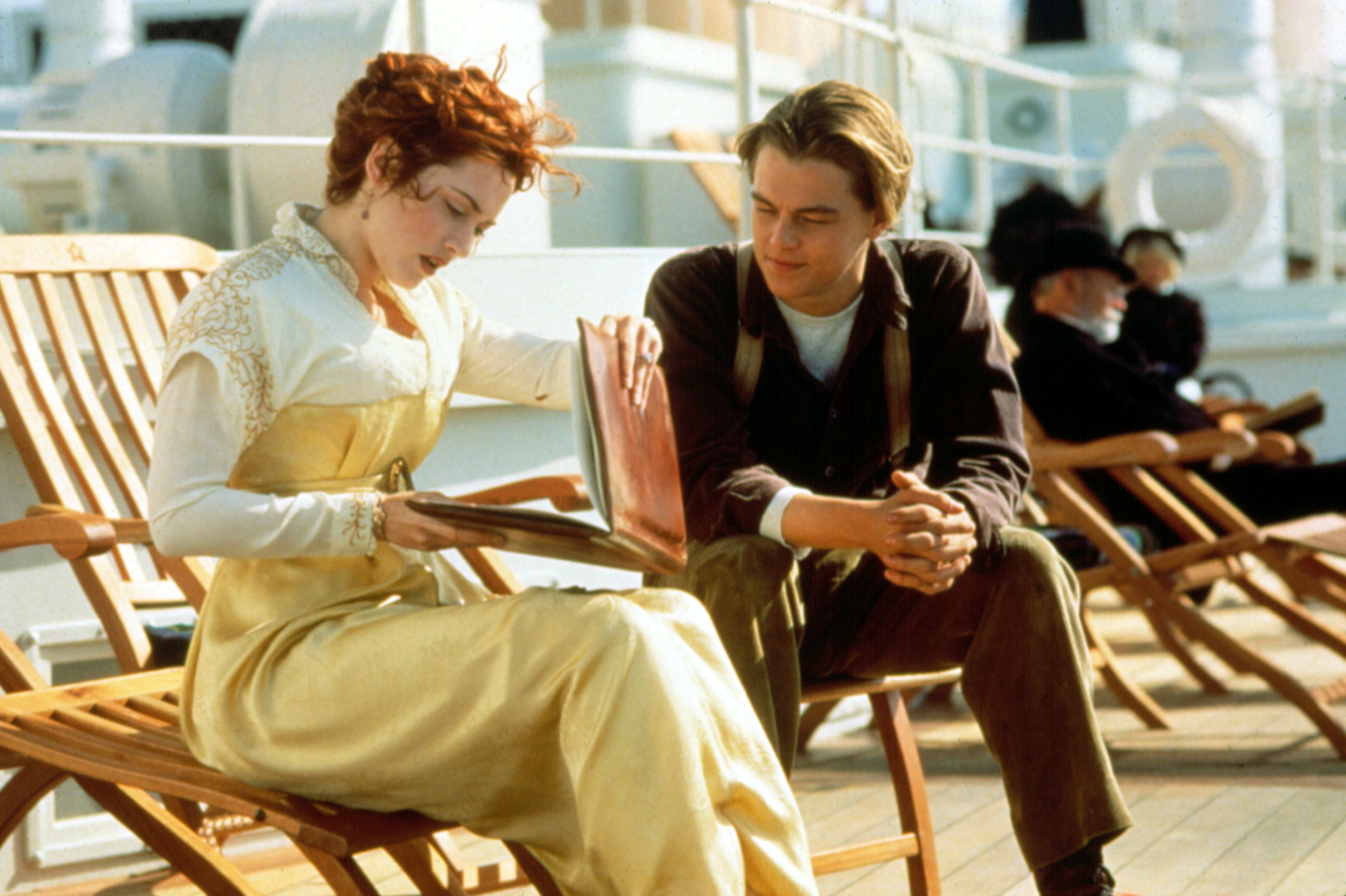 Rose looking through Jack&#x27;s sketches on the deck of the ship