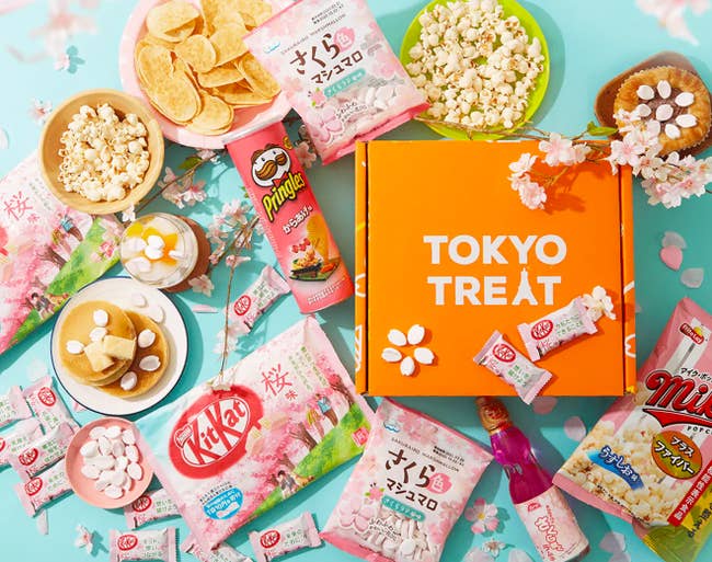 Several different candies and treats beside a TokyoTreat box 