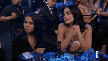 Camila Mendes and other woman looking bored at an awards show