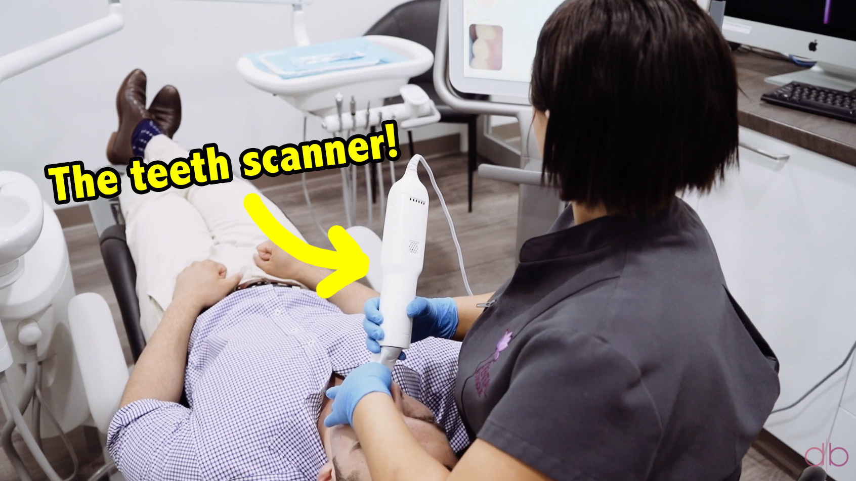 A dental employee scanning a patient&#x27;s teeth using a big white wand