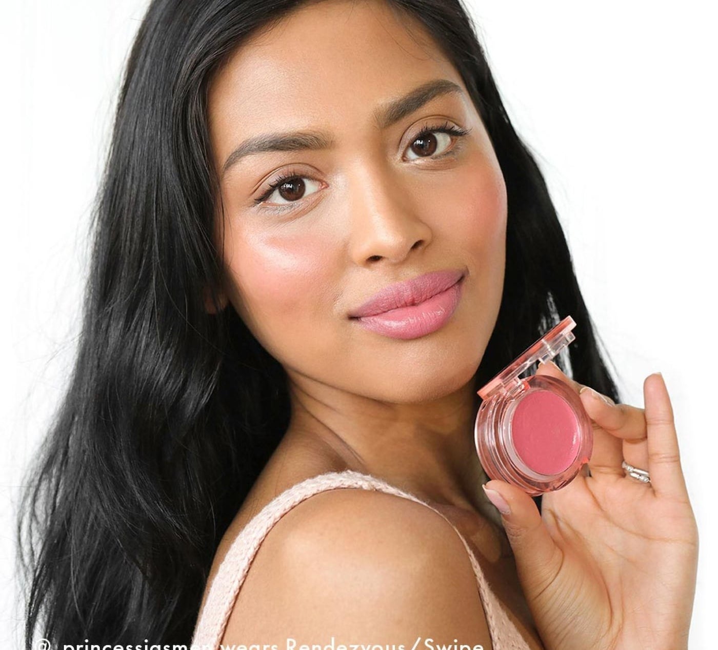 person holding the product with it on her cheeks and lips too