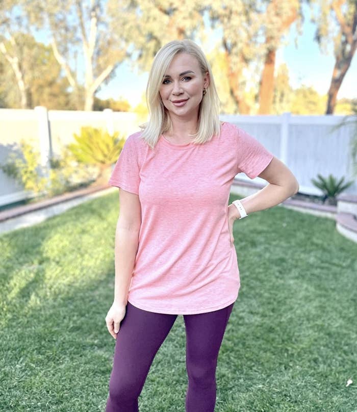 A person wearing a pink T-Shirt and purple leggings