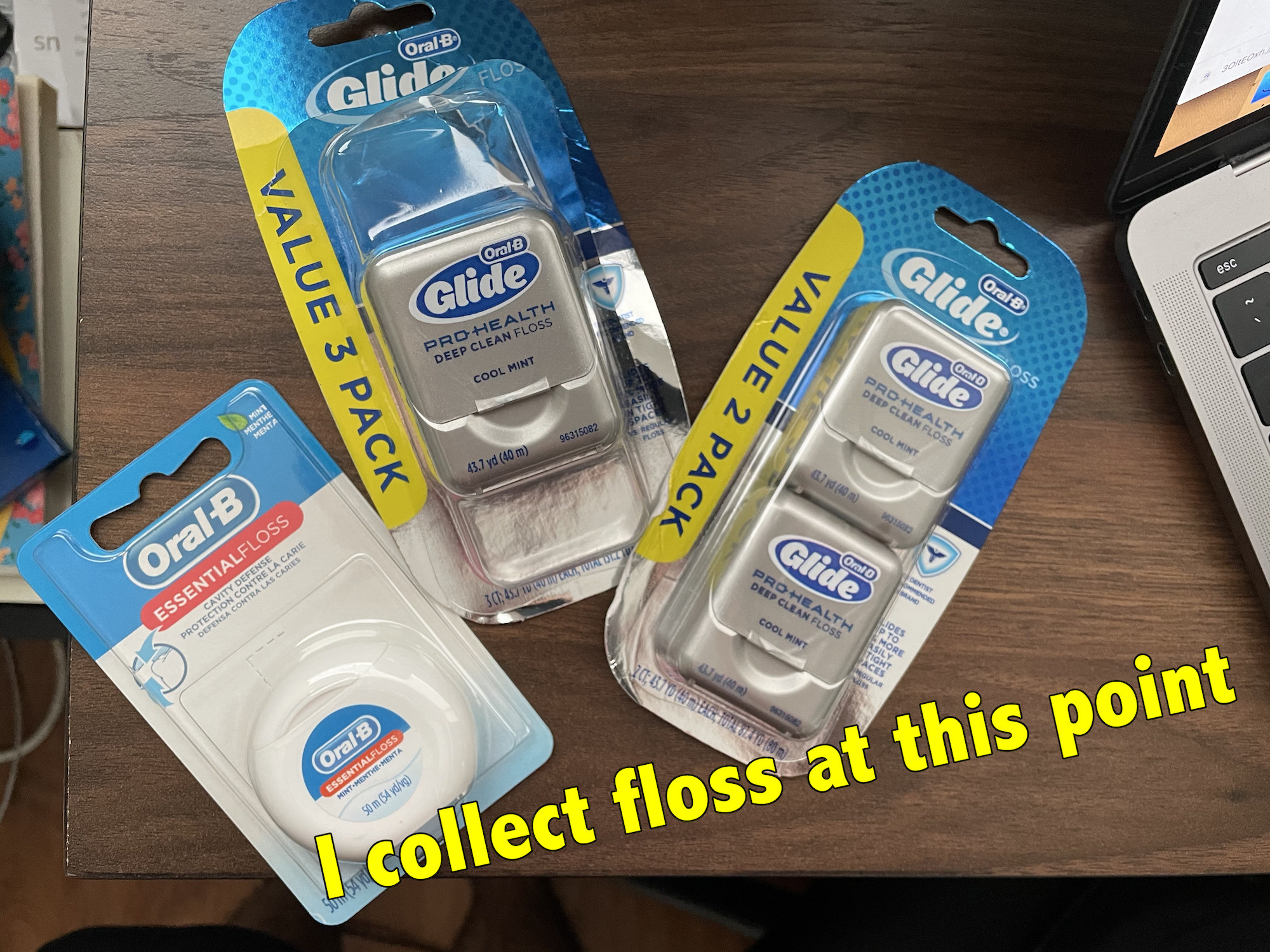 Four packs of dental floss on a desk