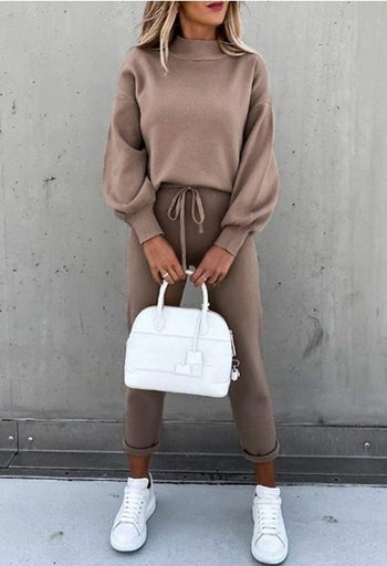 model wearing set in brown with a white handbag