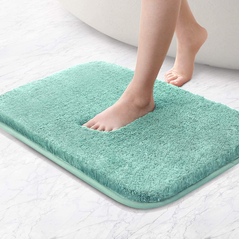 A person stepping on the plush memory foam bath mat