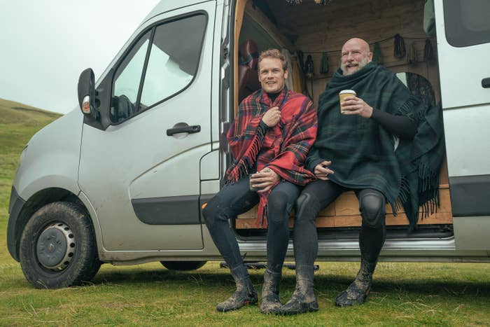 Sam and Graham wrapped in blankets as they sit in their van