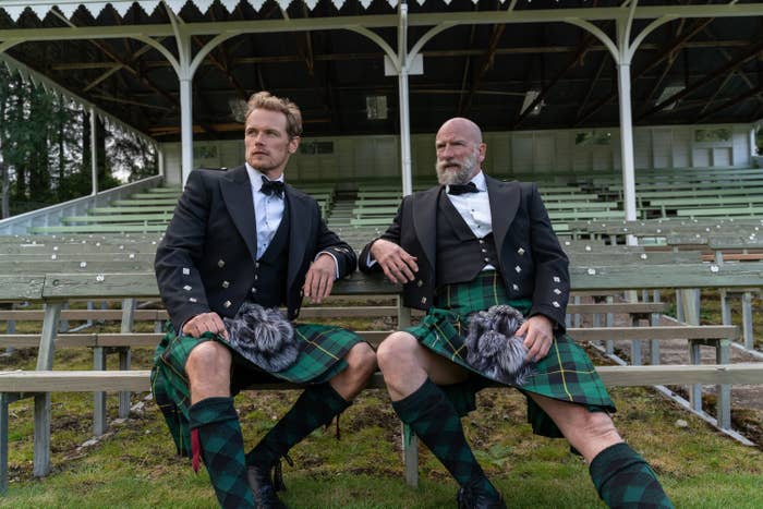 Sam and Graham rocking kilts as they sit on bleachers