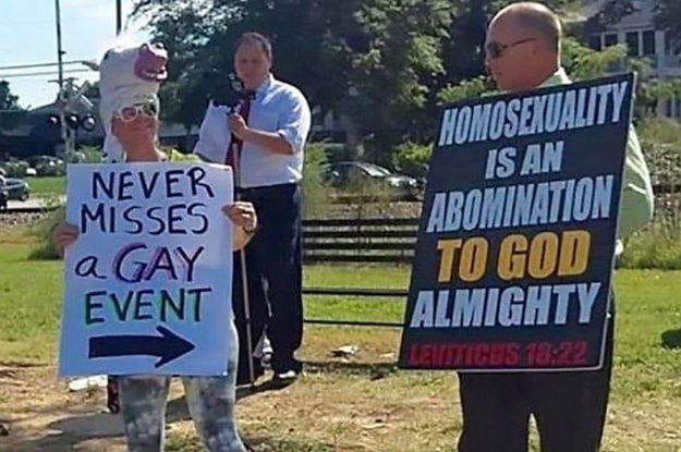 A counter protestor at an anti-gay rally holds a sign saying: they never miss a gay event