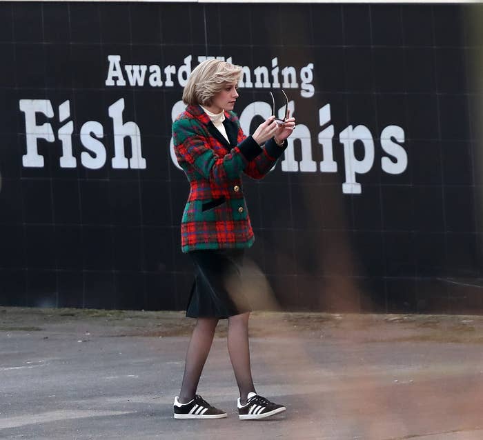 Kristen standing in front of a wall that has the words &#x27;Award Winning Fish &amp;amp; Chips&#x27; painted on it
