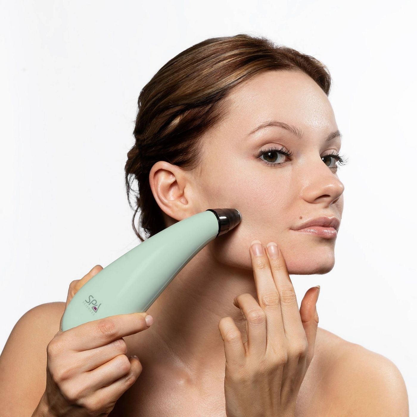 A model using a mint-colored microdermabrasion device