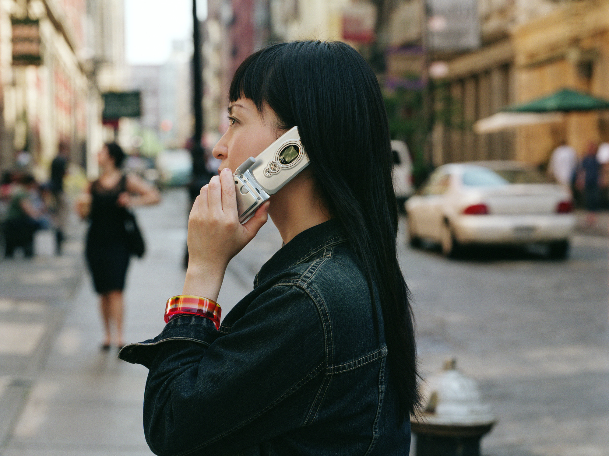 Someone talks on the phone using a flip cellphone