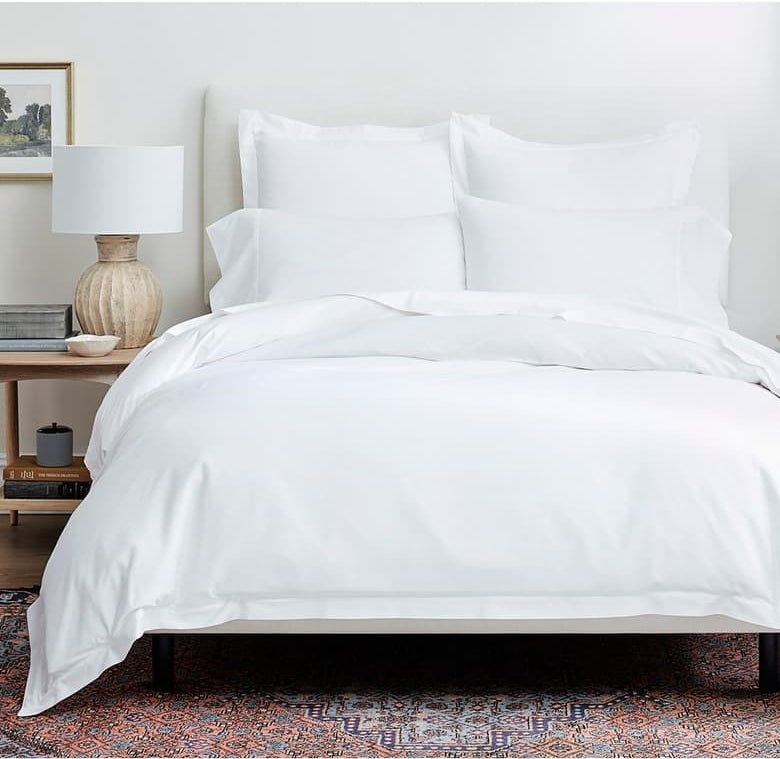 bed with white duvet cover and pillow shams