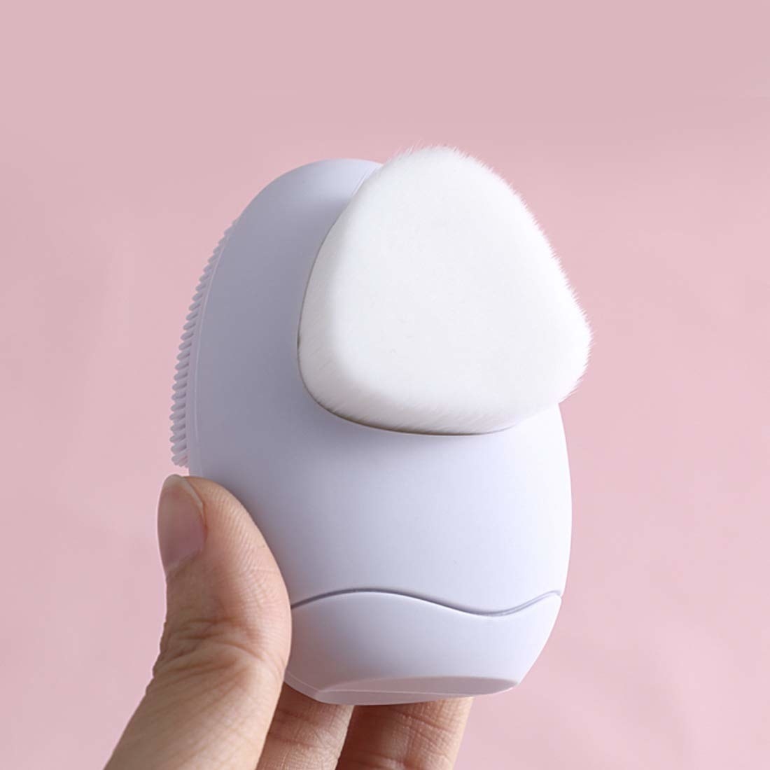 A hand holding the facial cleansing brush 