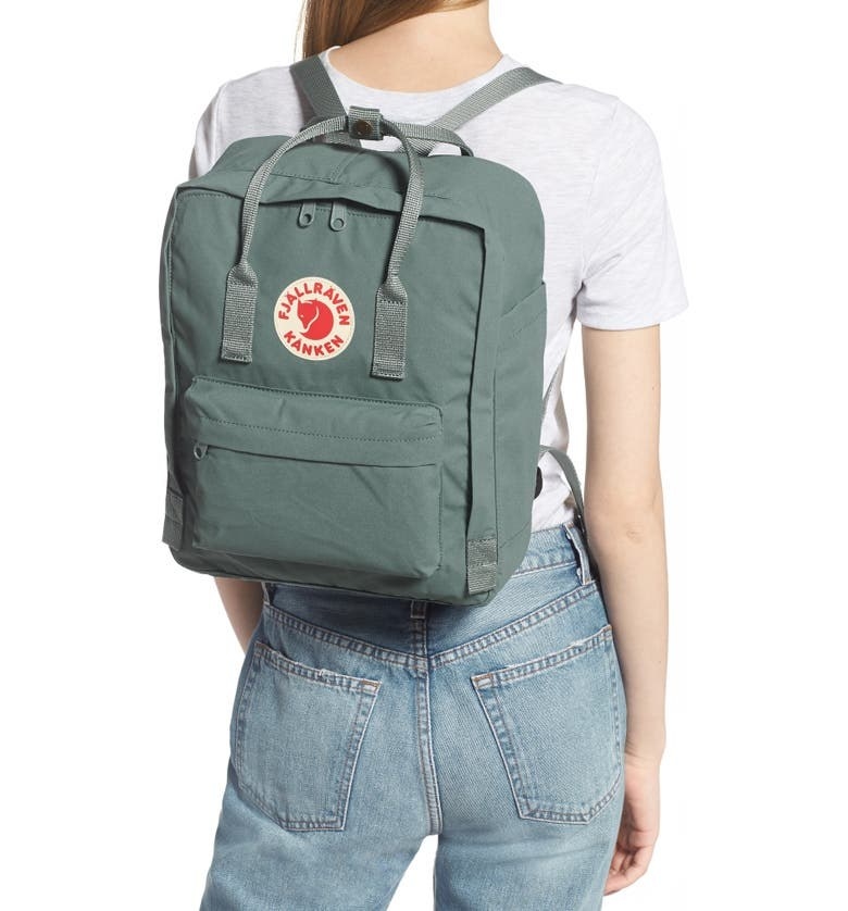 woman carrying a frost green fjallraven backpack