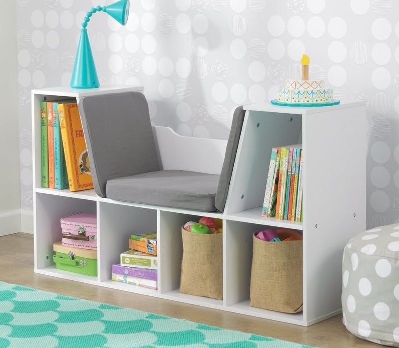 White bookcase with built-in gray padded bench