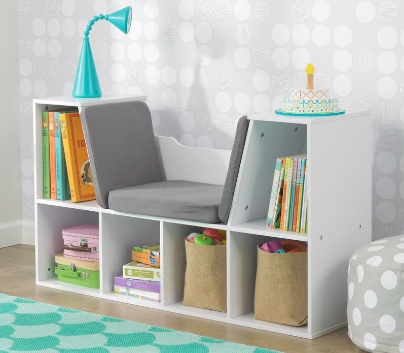 White bookcase with built-in gray padded bench