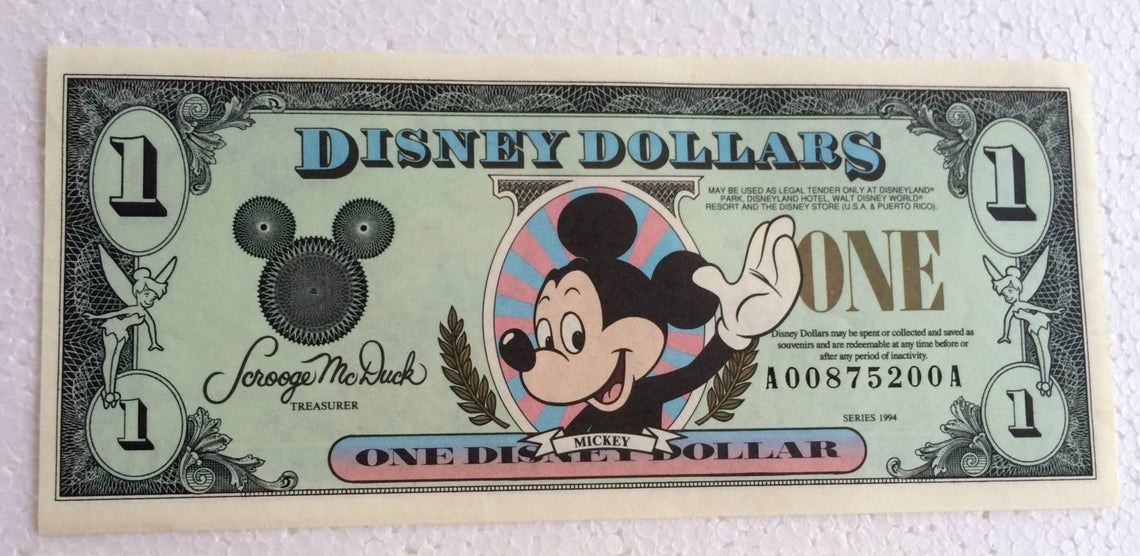 A one dollar Disney Dollar with Mickey waving on it