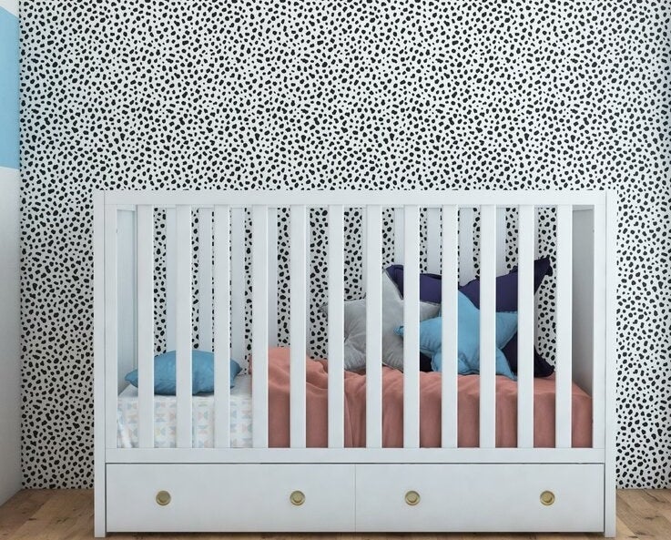 White convertible crib with storage drawer and gold hardware underneath