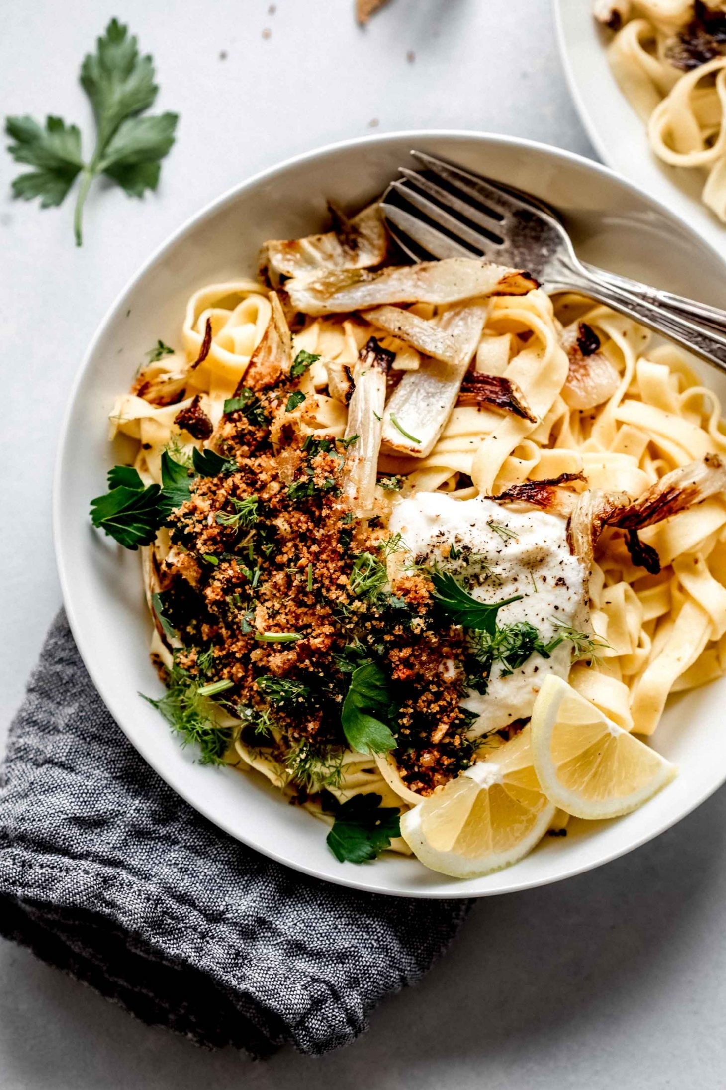 A plate of thick, long noodles with roasted fennel, bread crumbs, ricotta, and herbs.