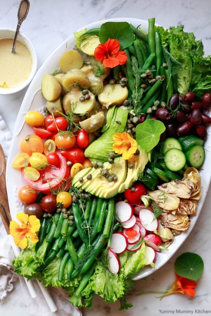 Niçoise salad with tomato, green beans, radish, cucumber, avocado, and more.