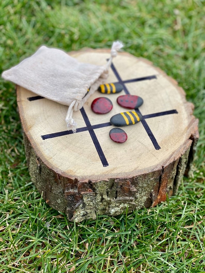 tree stump with painted rocks as a tic tac toe board