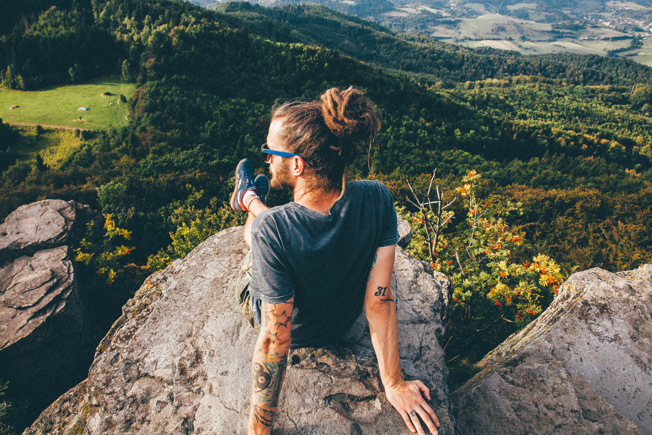 a man with long hair looking out at a nature view